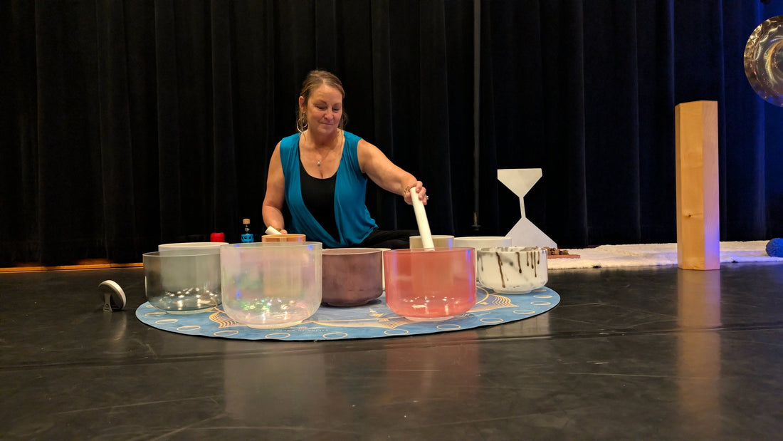 Practitioner playing crystal singing bowls during a sound bath session