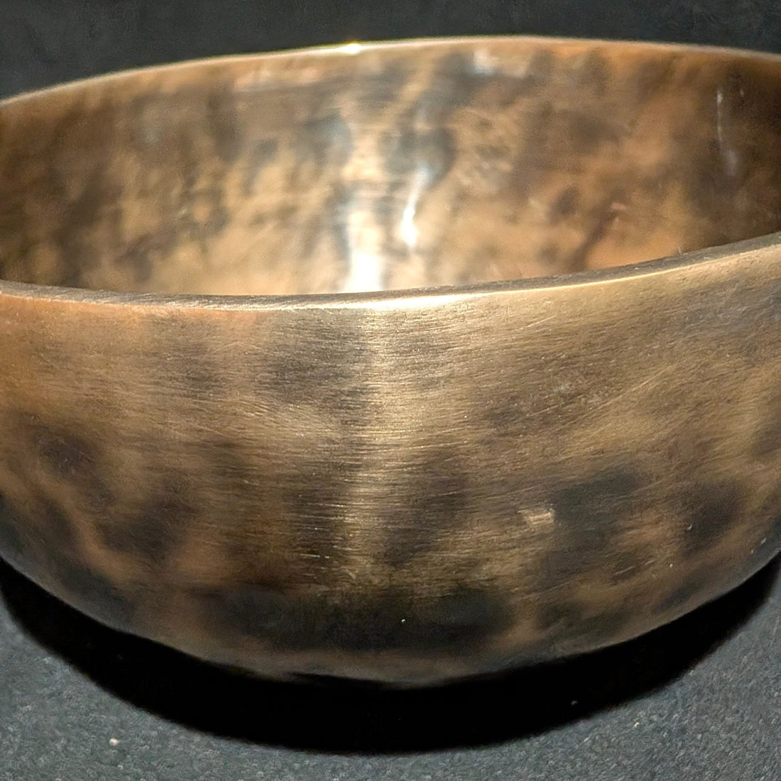 Hand-hammered bronze singing bowl, closeup of hammer marks on the bowl wall