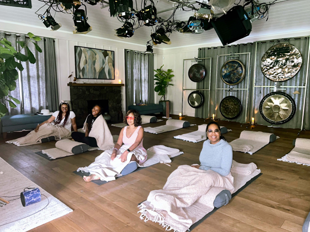 sound bath meditation session with four women and large gongs in studio setting