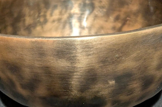 Hand-hammered bronze singing bowl, close-up of the rim
