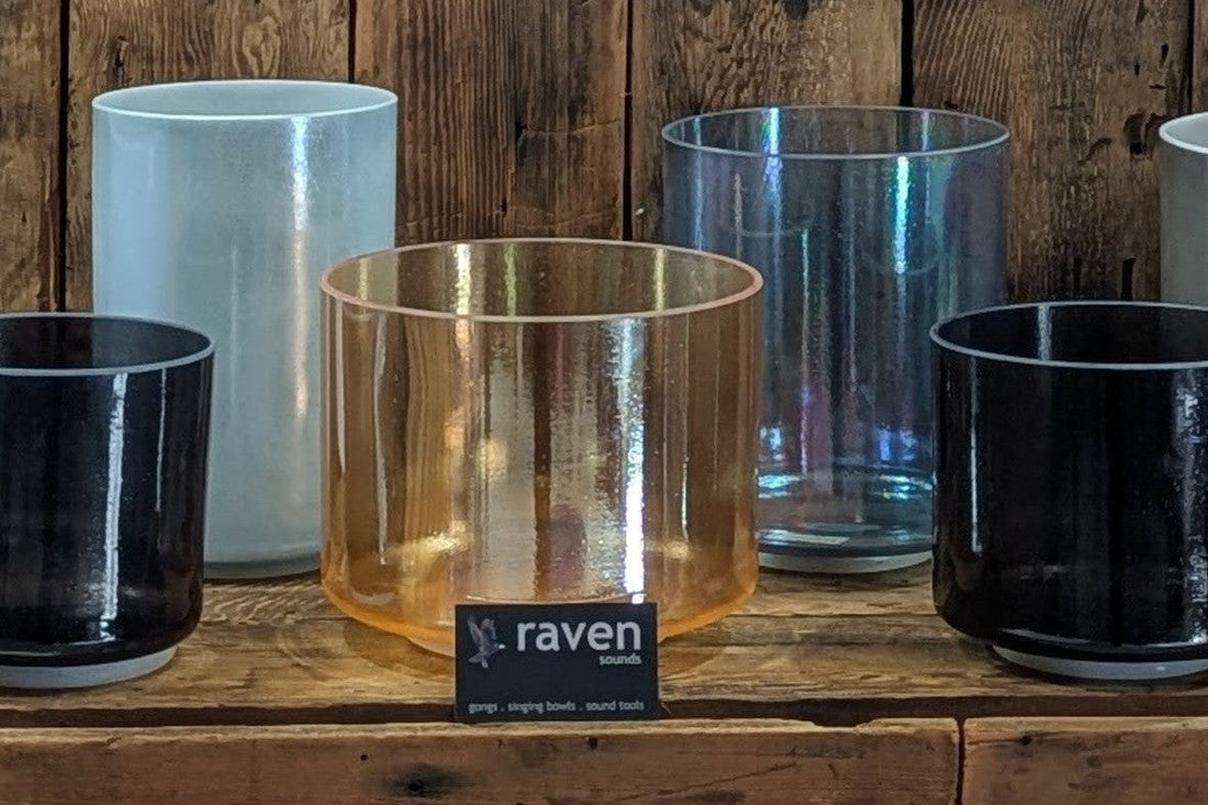 Crystal Tones singing bowls in a range of finishes on a wooden shelf
